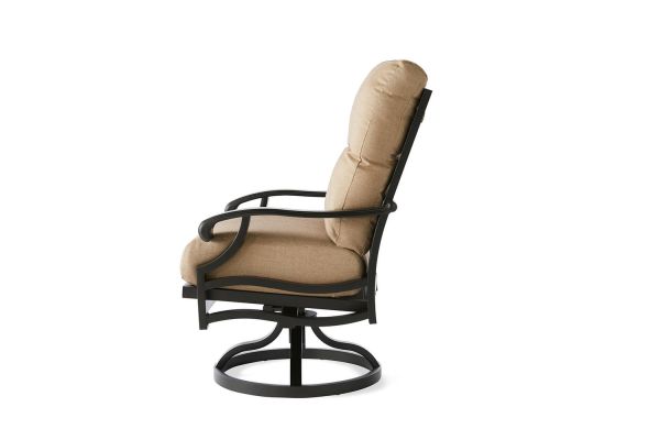 The Anthem Swivel Rocking Dining Armchair features a cushioned, beige design with a black metal frame, curved armrests, and a circular base, perfect for outdoor use.
