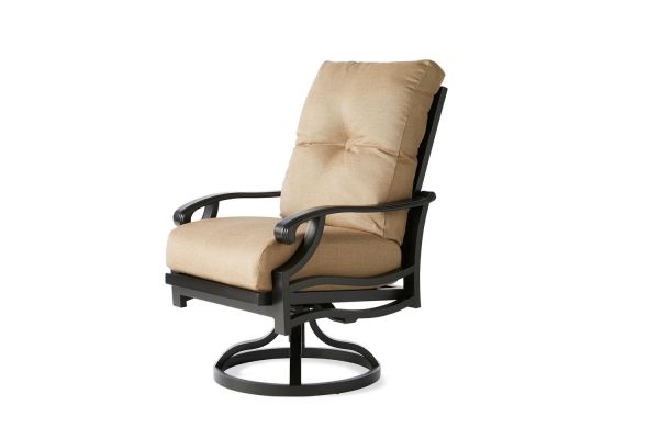 The Anthem Swivel Rocking Dining Armchair features a tan cushion, high backrest, armrests, and a black metal frame on a circular base.
