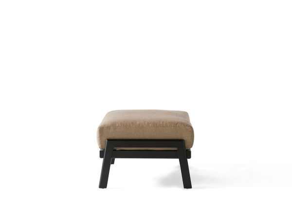 The Dakoda Cushion Ottoman features a beige cushion atop a black metal frame with slightly angled legs, enhancing its modern look. Set against a white background, the stylish design stands out.