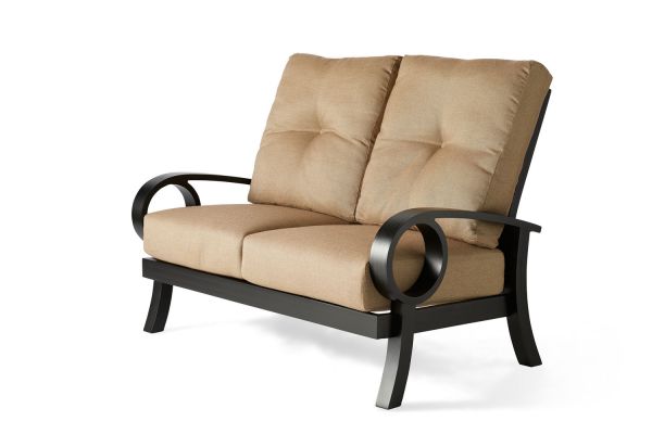 The Eclipse Love Seat features beige cushions, black metal arms, and a durable black frame with circular arm details and plush backrests. Its modern design exudes comfort against a plain white background.