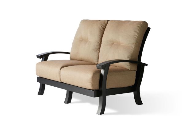 The Georgetown Cushion Love Seat is a minimalist two-seater sofa with beige cushions, a black metal frame, and curved armrests, set against a plain white background.