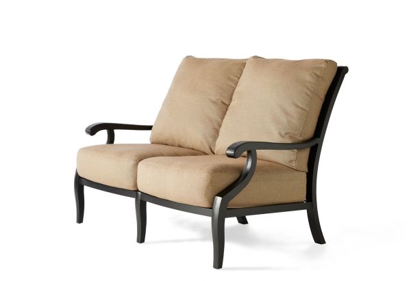 The Turin Cushion Love Seat is a beige two-seater sofa featuring curved black wooden arms and legs, shown from the side on a white background.