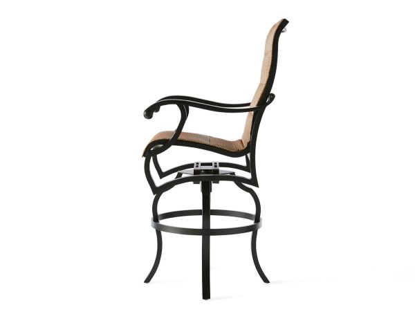 Side view of the Volare Padded Sling Swivel Bar Stool featuring a dark metal frame, tan woven seat and backrest, curved armrests, and a circular base with four legs.