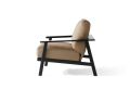 The Dakoda Cushion Lounge Chair is part of a patio set featuring geometric-patterned cushions, a sectional sofa, chairs, and a table on a brick patio surrounded by greenery under a pergola with lake views; theres also a bottle on the table.