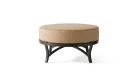 Volare Cushion Circular Ottoman features a round beige cushioned top with a black metal frame and curved legs, displayed on a simple white background.
